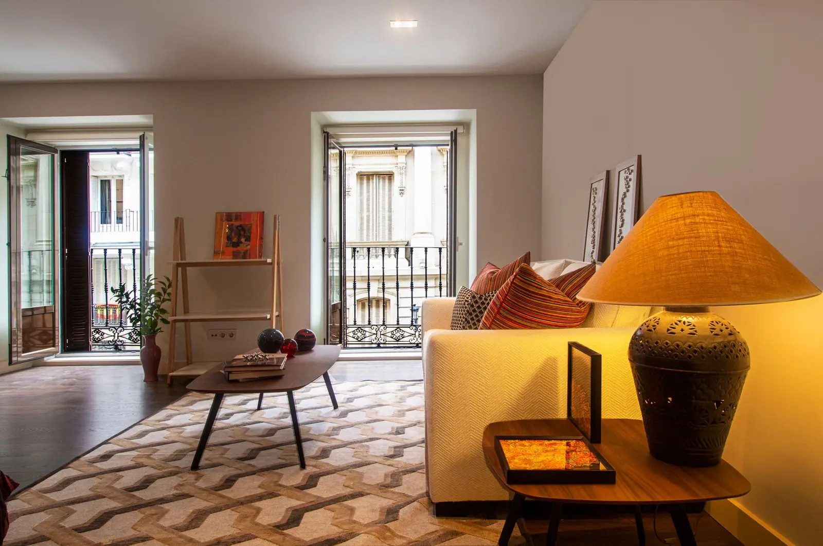 Salón con balcones, sofás claros y luz cálida